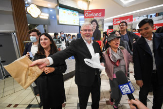 Kevin Rudd hands out treats to shoppers and the media pack, bought by the former PM from stores in Box Hill Central shopping centre on Tuesday.