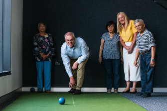 Scott Morrison tries his hand at indoor lawn bowls in the electorate of Solomon.