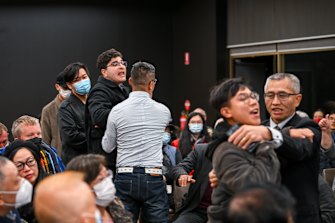 Two men who disrupted the forum are escorted from the hall.