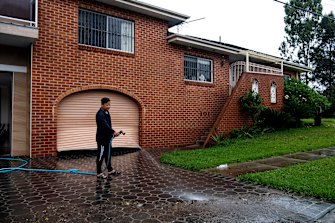 Lansvale resident Paul Huynh hosing down his driveway.