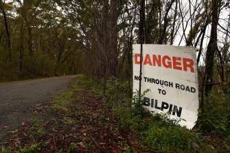 A sign stands among trees that show signs of regrowth after the Mt Wilson backburn in December. 