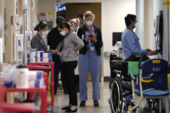 Medical workers fill a hallway in the acute care unit, where about half the patients are COVID-19 positive or in quarantine after exposure, of Harborview Medical Centre in Seattle.