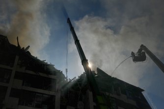 Emergency search and rescue conduct a recovery operation on top of an apartment building that was hit by a missile attack in central Kyiv. 