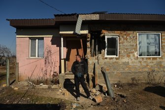 Volodymyr Khala, evini vurduktan sonra ön bahçesine düşen patlamamış bir füzenin yanında duruyor.