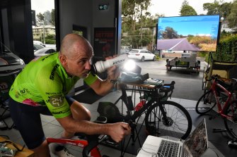 With the virtual road ahead on a big screen outside a Mona Vale car showroom as well as on a smaller screen in front of him, Rupert Guinness takes on the Virtual Race Across America. 