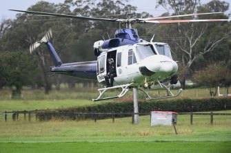 A police helicopter at Cobbitty where a man’s body has been located in a vehicle after being washed away in floodwaters.