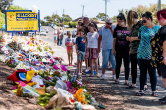 Mourners visit the makeshift memorial site at Hillcrest Primary School.
