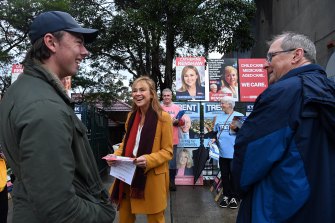 Labor candidate Catherine Renshaw (centre) talks with supporters before she casts her vote in the North Sydney electorate at Northbridge Public School.