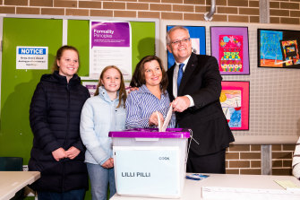 Prime Minister Scott Morrison and his wife, Jenny, vote while posing with their daughters today.