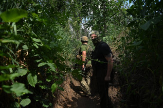 Commander of a Ukrainian armed forces unit Simon Salatenko (left) with his second-in-command Misyats walk along a trench on the front line near Krasnohorivka.