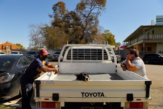 Wally Winters (left) and his brother Wayne Hames (right) with the dog Willow who are receiving their first shot of a COVID-19 vaccination at the Ochre Medical Centre in Brewarrina.