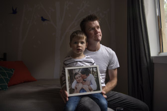 Nick Kelly and his son Xander holding a photo of Nicole, who died in January after being diagnosed with stage 4 adenoid cystic carcinoma in 2018. 