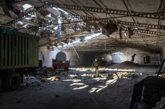 A Ukrainian army officer inspects a grain warehouse shelled by Russian forces, May 6, 2022. 