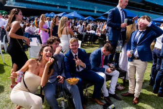 Spectators gather to watch the Melbourne Cup race via screen at Randwick.