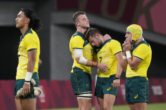 Australia’s Nick Malouf, centre left, and teammate Josh Turner embrace as the team reacts to its defeat by Fiji in their men’s rugby sevens quarter-final match in Tokyo.