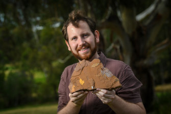 Dr Matthew McCurry from the Australian Museum with one of the fossils found at McGraths Flat. 