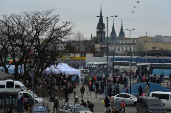 Oameni din afara gării din Lvov de unde pleacă trenurile și autobuzele spre Polonia.