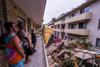 Residents in Dee Why are seen assessing the damage to an apartment block after  a “microburst” , a severe storm downdraft often with winds exceeding 100kph ripped roofs off and uprooted trees from Dee Why to Narrabeen. 