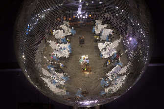Reflected on a mirror ball, health workers have a coronavirus test ahead of a music concert in Barcelona, Spain in March.