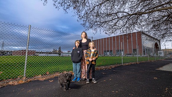 West Melbourne resident Mary Masters, with sons Gideon, 8, and Rupert, 6, and dog Maeby, standing in front of the new Arden station. Masters is concerned about Arden’s future. 