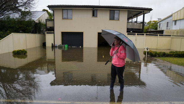 A woman stands in a flooded street at Windsor on the outskirts of Sydney on Tuesday.