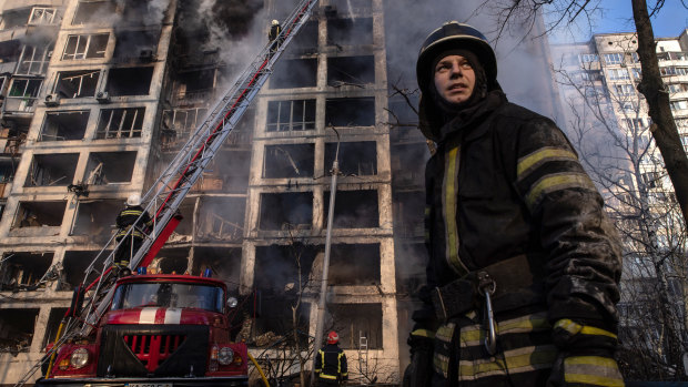 Firefighters work to extinguish a fire at a residential apartment building in Kyiv after it was hit by a Russian attack.