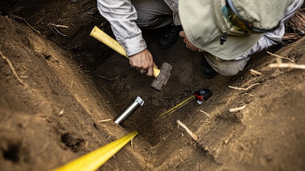 Dr Daryl Lam from Water Technology takes a sediment sample using a stainless-steel tube on the banks of the Nepean.