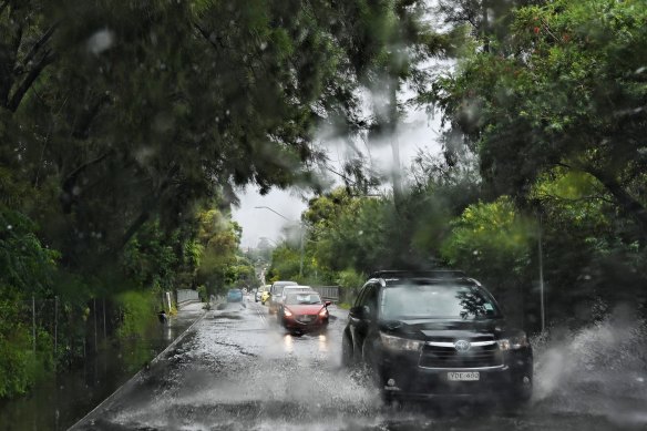 Cars make their way through floodwater in Marrickville today.