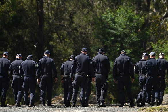 NSW Police conduct a line search walking towards the mound of dirt where the bodies believed to be Luke Davies and Jesse Baird were discovered