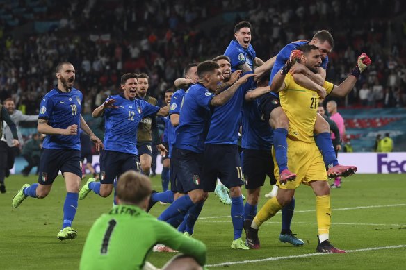 Italian teammates swamp goalkeeper Gianluigi Donnarumma.