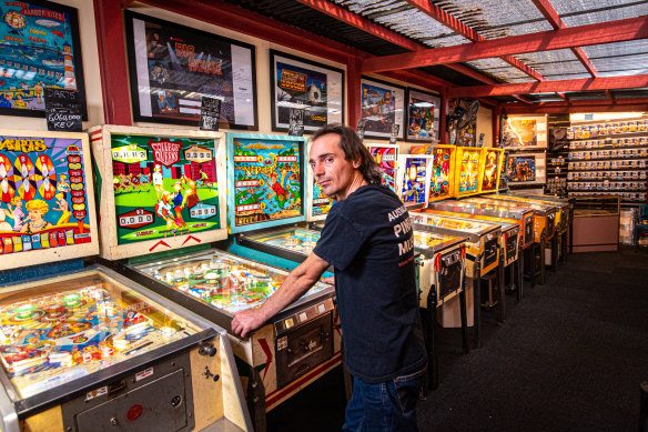 Australian Pinball Museum owner Lyndon Carter with games including Darts and Nip-It.