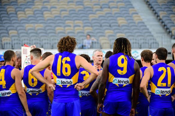 Adam Simpson addresses his team at three-quarter time during the Eagles' round one clash against the Demons. The game, played to an empty Optus Stadium, was likely the last of the 2020 season. 