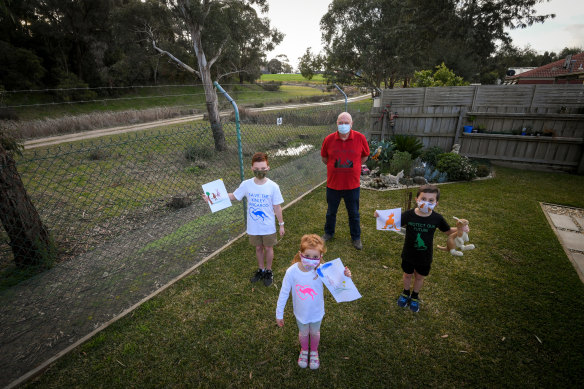 Lilydale resident Ian Fairweather and his grandchildren, Heidi, 4, Sammy 7 and Jack 11 in his backyard on Thursday.