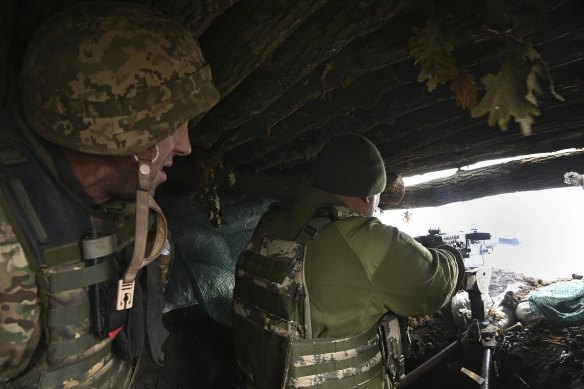 Anton (right) who is in charge at a forward infantry position with the 68th brigade fires a gun at the enemy line.