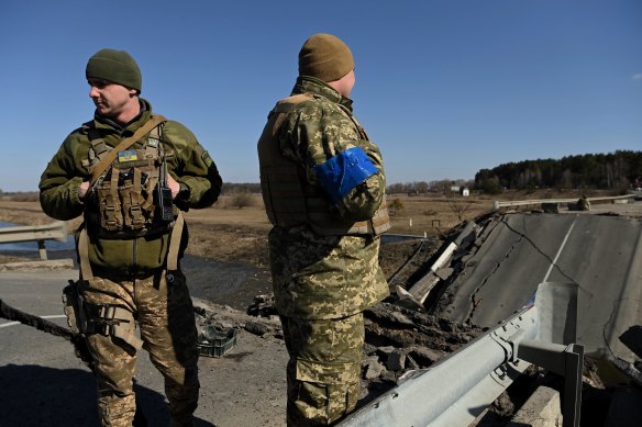 Ukrainian soldiers with the 72nd Brigade  on a destroyed bridge in a village east of Kyiv.