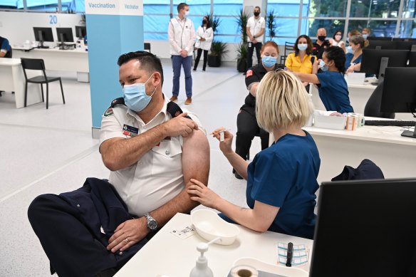 NSW RFS Inspector Ben Shepherd is among emergency services workers to receive a vaccine dose at the Olympic Park site. 