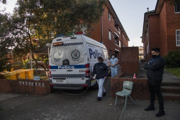 Health workers leaving an apartment block in Campsie, Sydney, earlier this morning. 
