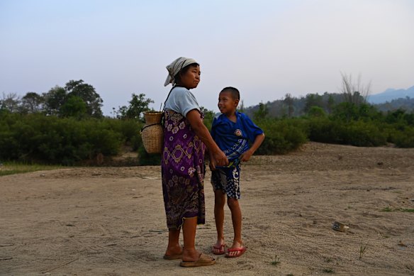 In the late afternoon a woman and child arrive on the banks of the Moei River in Thailand after crossing the river near Pu Lu Palaw village in Myanmar.