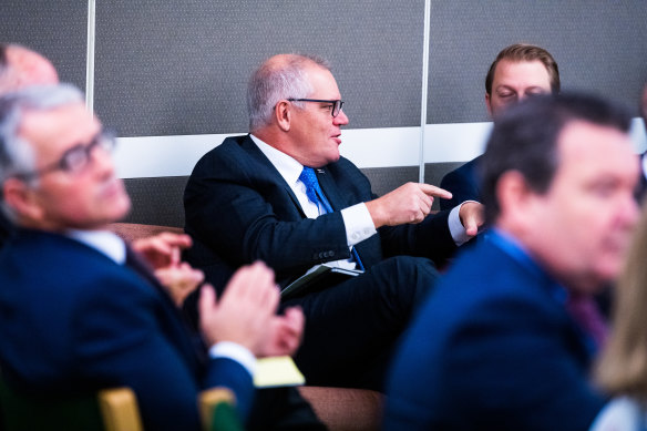 Former prime minister Scott Morrison speaking to Liberal Senator James Paterson at a party room meeting last month. 