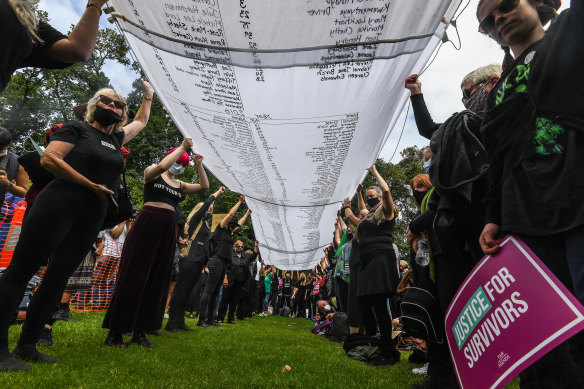 Protesters hold up at a list with the names of more than 800 women and children killed in domestic violence incidents since 2008.