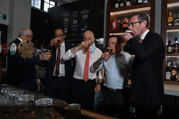 NSW Premier Dominic Perrottet enjoys a beer on Monday with Deputy Premier Paul Toole and Treasurer Matt Kean at Watson’s Pub in Moore Park.