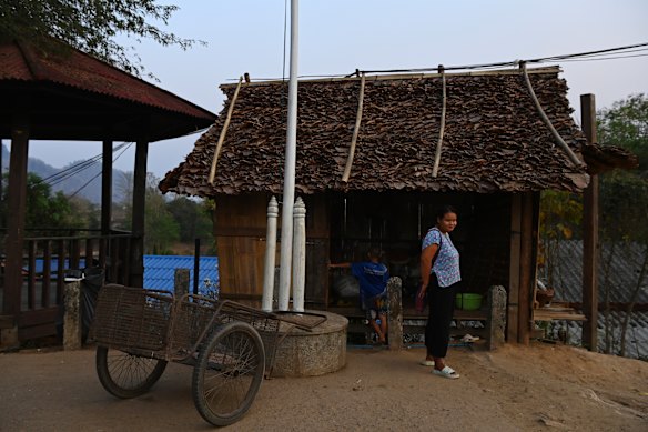 A woman stands at her shop in Thailand, just over the river from Myanmar. 