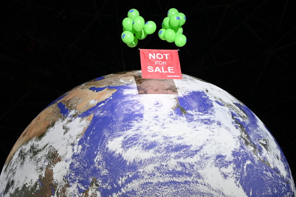 Greenpeace activists float a sign over a globe at the COP26 summit venue. 