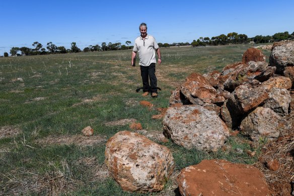 Farmer Adrian McMaster points to rocks he accidentally removed from an ancient Aboriginal stone arrangement in Lake Bolac.