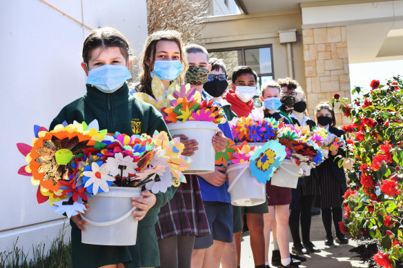 Students from several schools in Melbourne's east deliver paper flowers to residents of Arcare Knox.