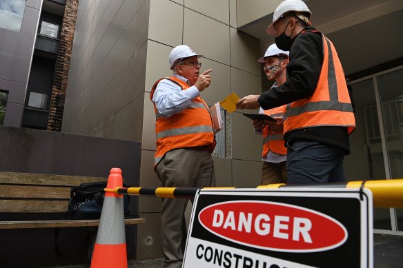 NSW Building Commissioner David Chandler, left, talks about the removal of cladding from a Darlington apartment building.