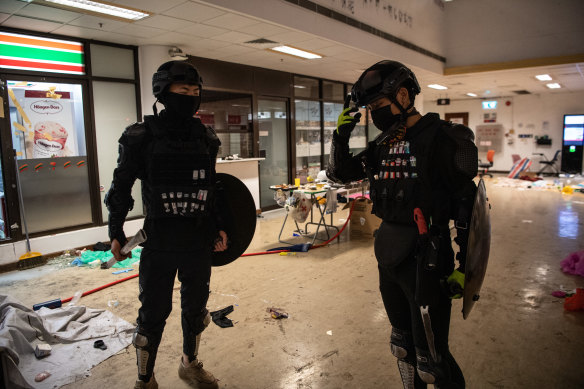 Anti-government protesters with their faces covered stand at Hong Kong Polytechnic University.