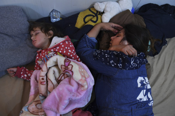 A woman and her child sleep in an Iraqi receiving area for refugees at Sehelan, on the Iraq-Syria border.