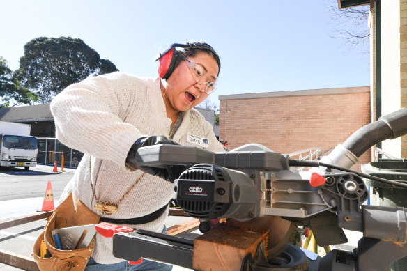 Queen Dechoe Legend from Dee Why gets instructions on using a circular saw.