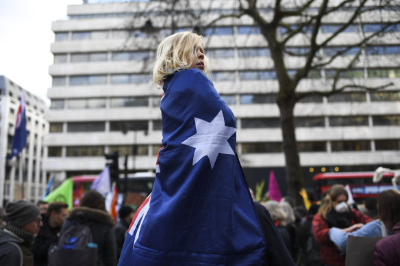 A young child wrapped in an Australian flag listens to speakers at the protest. 